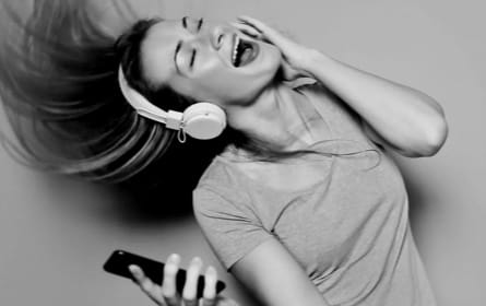 woman singing with XX59 Headphones on