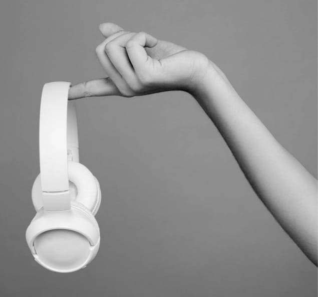 XX59 Headphones being held out by womans finger